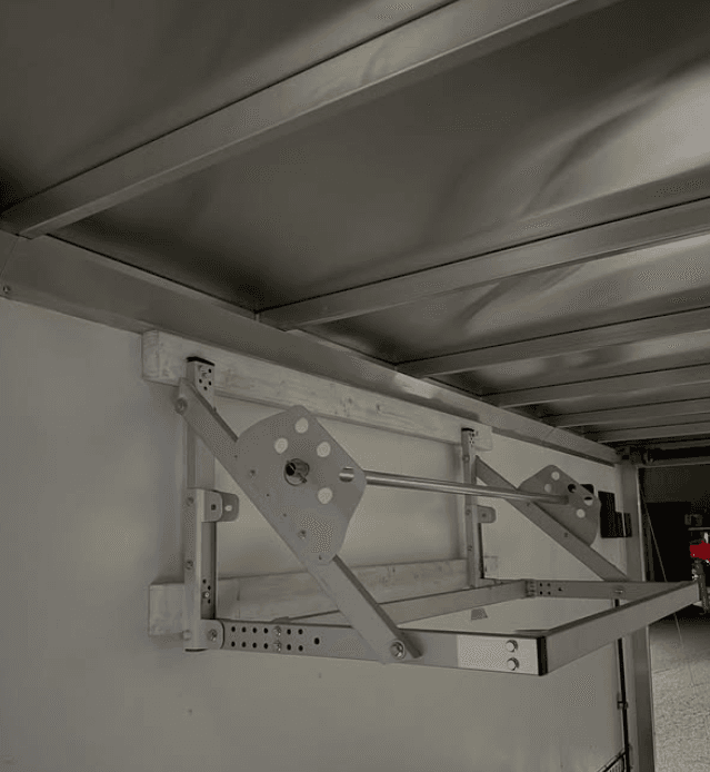 Custom-fabricated fold-down aluminum rack mechanism inside a trailer