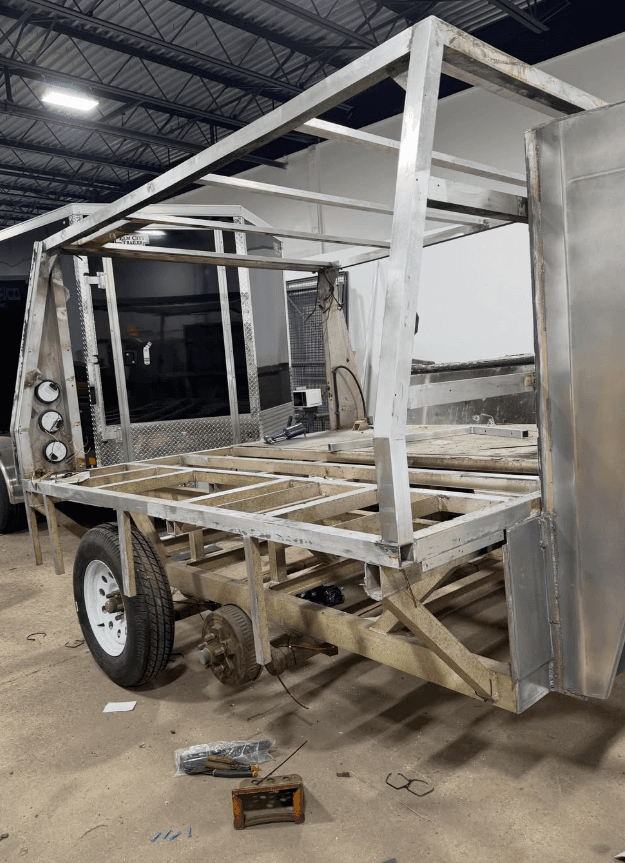 Bare aluminum trailer frame being fabricated in the shop