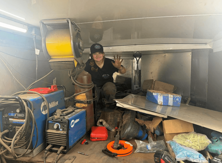 Taylor's technician welding inside a trailer with Miller welders and tools
